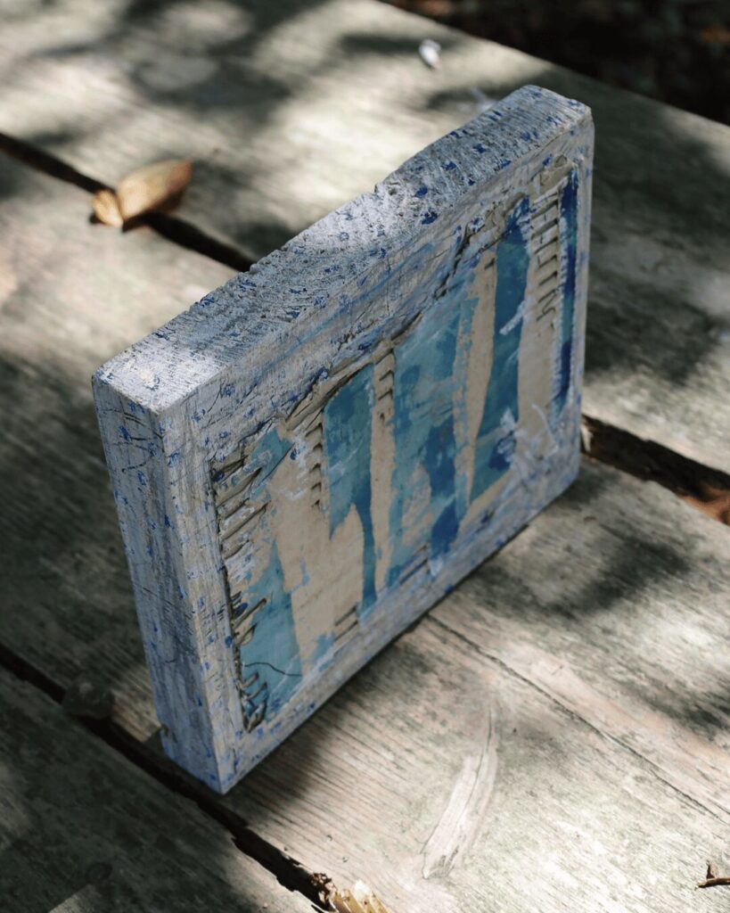 "Objects, No. 10," an angled perspective of a raw, highly textured art object, revealing the rugged profile of its collaged corrugated cardboard construction. The blue-painted surface appears intentionally weathered and stripped away, exposing the raw, tactile material beneath. This Wabi Sabi style piece is from the 'Objects' series by Asahi Tanaka.